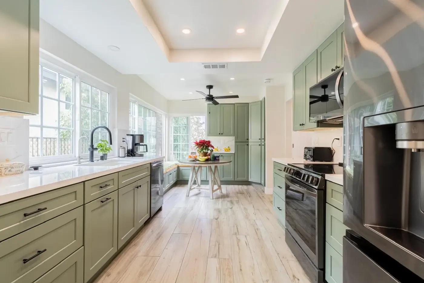 Sage green cabinetry with white countertops
